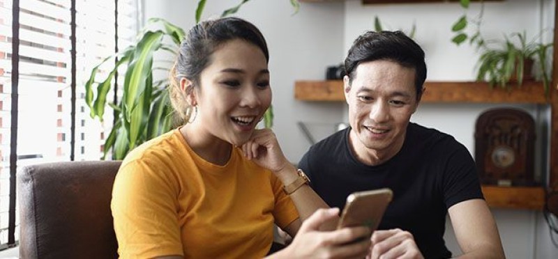 Two people looking at one phone